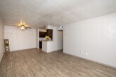 Located at 2501 Lake Rd in Huntsville, Texas, this single-floor unit offers a practical and comfortable layout across well-defined living spaces. The living area greets you with warm wood-look flooring, a ceiling fan, and a textured ceiling, creating a bright and welcoming atmosphere. A large window with horizontal blinds allows natural light to fill the room, enhancing its open feel.

The galley-style kitchen is a standout feature, lined on both sides with rich dark-wood cabinetry and granite-style countertops. Stainless steel appliances — including a refrigerator, electric range, microwave, and dishwasher — are complemented by a stainless steel sink and a tile backsplash. A pass-through peninsula connects the kitchen to the living area, offering added functionality and an open sightline between the two spaces.

The bedroom features soft carpeting underfoot, a ceiling fan, and a window with exterior views, providing a cozy and restful retreat. The bathroom is fitted with wood-look flooring, a full tub-shower combination with floor-to-ceiling earth-toned tile surround, and a curved shower curtain rod for added comfort. Throughout the unit, textured walls and consistent flooring choices create a cohesive and clean aesthetic well-suited for everyday living.