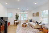 Located at 2701 Rozzelles Ferry Road in Charlotte, NC, this modern multi-level home offers three bedrooms, four bathrooms, and a well-organized layout spread across four floors. The ground level includes an attached garage with overhead lighting and window access, providing generous storage and parking. Light wood flooring flows throughout the upper levels, complemented by crisp white walls and recessed lighting that create a bright, cohesive aesthetic. The main living floor features an open-concept design where the kitchen, dining room, and living room connect seamlessly. The kitchen is outfitted with white shaker cabinetry, a large center island with bar seating, pendant lighting, stainless steel appliances, and a clean white countertop. The adjacent dining area is bathed in natural light from multiple windows and offers direct access to a private balcony. The living room is equally well-lit, with large windows framing outdoor views and a staircase with sleek black metal railings anchoring the space. Bedrooms are comfortable and bright, with large windows overlooking the neighborhood. The bathrooms feature elegant marble-style tile walk-in showers with black-framed glass enclosures. Five closets, including walk-in options with built-in shelving, provide ample storage. A dedicated laundry area adds everyday convenience to this well-appointed Charlotte home.