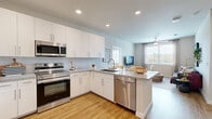 This thoughtfully designed 2-bedroom, 2-bathroom home in Houston, TX offers a functional and modern living experience across a single floor. The open-concept kitchen and living area serves as the heart of the home, featuring white shaker cabinetry, granite countertops, a peninsula with sink, and a full suite of stainless steel appliances including an electric range, microwave, and dishwasher. Warm wood-look flooring and recessed lighting complete the clean, contemporary aesthetic. The kitchen flows seamlessly into a bright living room bathed in natural light from large windows, and is equipped with a ceiling fan for year-round comfort. Both bedrooms are well-sized and comfortable, with the primary bedroom offering ample space and access to a private en-suite bathroom featuring a granite-topped vanity with white cabinetry and a large mirror. Each bedroom is served by its own dedicated closet, both outfitted with wire shelving systems and generous hanging space for organized storage. A hallway connects the rooms efficiently, maintaining a practical layout throughout. The neutral color palette, quality finishes, and abundant natural light create a clean, inviting ambiance well-suited for everyday living in the Katy area of Houston.