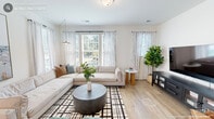 This well-designed three-story home in Durham, NC offers a thoughtful layout spread across three floors, featuring 2 bedrooms, 4 bathrooms, a dedicated office, and a dedicated laundry room. Light hardwood flooring runs throughout the main living areas, contributing to the home's bright, contemporary aesthetic.

The main level showcases an open-concept living, dining, and kitchen area bathed in natural light from multiple large windows dressed with striped linen curtains. The kitchen is a standout, featuring crisp white cabinetry, a center island with bar seating, stainless steel appliances, and generous counter space. The adjacent dining area is anchored by an elegant chandelier and opens seamlessly to the living room, which offers a relaxed, welcoming atmosphere.

The upper levels house the two spacious bedrooms, each with plush carpeting, ample closet space, and windows that invite natural light. The generously sized primary bedroom provides a comfortable retreat. The four clean, modern bathrooms feature light wood-look flooring and white vanities.

A dedicated office on the lower level offers a quiet, spacious work-from-home environment with recessed lighting, hardwood floors, and a wall-mounted climate control unit. A dedicated laundry room with in-unit washer adds everyday convenience to this well-rounded home.