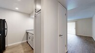 Located at 202 E Baseline Rd in Tempe, Arizona, this single-floor, three-bedroom, two-bathroom unit offers a practical and well-appointed layout. The open living room features wood-style plank flooring and a textured ceiling, with a large sliding glass door fitted with vertical blinds that fills the space with natural light. Adjacent to the living area, the kitchen is thoughtfully designed with white cabinetry, a mosaic tile backsplash, light countertops, and black stainless appliances including a range, microwave, and refrigerator. Wood-style flooring continues throughout the kitchen and main living areas, creating a cohesive look. The two bathrooms are clean and functional, each featuring white vanities with gray countertops, updated hardware, and a tub-shower combination. The bedrooms offer a mix of flooring — some with warm wood-style tile and others with plush carpet — providing comfort and versatility. Two closets and two hallways add practical storage and ease of navigation throughout the unit. Neutral wall tones and consistent finishes give the home a clean, move-in-ready feel well suited for everyday living in the Tempe area.