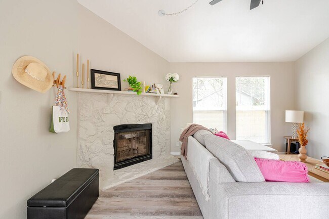 Sala de estar con chimenea, ventanal grande y persianas nuevas en toda la casa. - 6307 Okner Ln
