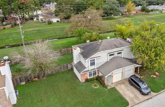 Vista aérea que muestra la estructura de varios pisos ubicada en una amplia propiedad verde. - 10038 Spring Place Dr