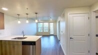 This 540 square foot apartment in Salt Lake City showcases efficient use of space with a modern, open-concept design. The heart of the home is a combined kitchen and living area, featuring sleek wood-toned cabinetry, stainless steel appliances, and a practical kitchen island that doubles as a dining space. Pendant lighting adds a touch of contemporary elegance.

The bedroom, measuring 150 square feet, offers a cozy retreat with large windows that flood the space with natural light. The bathroom is equipped with a full-sized bathtub and shower combination, complete with built-in shelving for added convenience.

Throughout the apartment, neutral tones and wood-look flooring create a cohesive, contemporary aesthetic. Large windows in the living area and bedroom not only brighten the space but also offer views of the surrounding urban landscape. The unit also includes a closet for storage.

This apartment, located at 308 W North Temple St in Salt Lake City, provides a perfect balance of style and functionality for modern urban living. Its thoughtful layout maximizes the available space, making it an ideal choice for those seeking a compact yet comfortable home in the heart of the city.