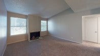 Located at 10010 Whitehurst Dr in Dallas, TX, this single-floor unit offers a well-organized layout designed for comfortable everyday living. The living room is a welcoming centerpiece, featuring a classic fireplace flanked by two windows that fill the space with natural light. Textured ceilings and neutral-toned walls appear throughout, creating a consistent and clean aesthetic. Plush carpet flows through the living areas and bedrooms, while durable wood-look flooring defines the kitchen and dining areas.

The kitchen is efficiently designed with white cabinetry, speckled stone-look countertops, a decorative mosaic tile backsplash, and white appliances including a refrigerator and electric range. A pass-through counter connects the kitchen to the adjacent dining or flex space, enhancing the sense of openness.

The bedrooms are comfortably sized with carpet flooring and ceiling fans to promote airflow. The primary bedroom benefits from direct access to a spacious walk-in closet with built-in shelving, as well as a private en-suite bathroom. The bathroom features a single vanity with a large mirror, speckled countertop, and a shower-tub combo. Additional utility is provided by a visible electrical panel and ceiling-mounted HVAC vents throughout the unit.