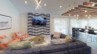 Located at 1029 Spa Road in Annapolis, Maryland, this single-floor community clubhouse showcases a thoughtfully designed open-concept layout that seamlessly connects multiple functional zones. The main gathering area is anchored by dramatic vaulted ceilings adorned with a striking arrangement of exposed wood beam slats and globe pendant lighting, creating a warm yet contemporary ambiance. Rich wood-tone flooring runs throughout, grounding the space and complementing its modern aesthetic.

The lounge area is generously appointed with plush sectional and accent seating arranged around a central coffee table, while a bold geometric-patterned feature wall serves as a backdrop for a wall-mounted flat-screen display. A built-in workstation nook with desk and task seating provides a dedicated space for productivity. Floor-to-ceiling sheer drapery lines the expansive windows and sliding glass doors, allowing abundant natural light to flood the interior while offering views of the surrounding greenery.

Bar-height counters with modern stools offer additional casual seating along the perimeter. A fully equipped kitchen, featuring dark cabinetry, stainless steel appliances, and light countertops, supports events and gatherings. The high ceilings and open sightlines throughout lend the space an airy, welcoming character well-suited for community use.