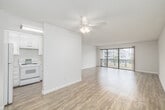 Located at 1000 S Catalina Ave in Redondo Beach, CA, this well-appointed one-bedroom, one-bathroom residence offers a bright and functional layout across a single floor. The open-concept living and dining area is a standout feature, finished with light wood-tone flooring and bathed in natural light from expansive sliding glass doors that open onto a private balcony with neighborhood views. A textured ceiling adds subtle character throughout the main living spaces. The kitchen is efficiently designed with white cabinetry, a pass-through counter connecting to the living area, and includes a full-size refrigerator and range. An adjacent built-in shelving nook provides additional storage and display space. The generously sized bedroom features plush carpeting, a large window with vertical blinds, and a mirrored sliding closet door that enhances the sense of space. A dedicated walk-in closet off the bedroom hallway offers dual clothing rods and ample shelving. The bathroom is accessed via a short hallway and includes a shower-tub combo with a glass enclosure. Clean white walls and a neutral palette throughout create a cohesive, move-in-ready environment well-suited to the relaxed coastal lifestyle of Redondo Beach.