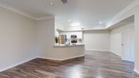 This single-story, 2-bedroom, 1-bathroom home in Round Rock, TX offers a thoughtfully designed layout with consistent wood-look flooring and neutral warm tones throughout. The open-concept kitchen and living area serves as the heart of the home, featuring a peninsula with bar seating, crisp white cabinetry, stainless steel appliances including a refrigerator, range, and microwave, and recessed lighting. Crown molding adds a refined architectural touch to the living space, which is further complemented by a ceiling fan overhead.

The spacious primary bedroom benefits from abundant natural light through large sliding glass doors with vertical blinds, crown molding, a ceiling fan, and direct access to a generous walk-in closet outfitted with dual hanging rods and shelving on three walls. The second bedroom offers comparable finishes with crown molding and wood-look flooring.

The full bathroom includes a wide vanity with a white countertop and under-sink storage, a soaking tub with a curved shower rod and tile surround featuring decorative diamond accents, and wood-look flooring. A dedicated laundry area houses a full-size washer and dryer with overhead shelving. The attached garage provides additional storage and parking convenience.