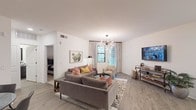 Located at 240 W Osborn Rd in Phoenix, AZ, this single-story residence offers a thoughtfully designed open-concept layout with modern finishes throughout. The living room serves as the centerpiece of the home, showcasing light wood-style flooring, crisp white walls, and a striking sputnik chandelier that adds a bold decorative touch. Natural light pours in through a glass door and windows dressed with elegant floor-to-ceiling curtains, offering views of lush outdoor greenery. A cozy seating arrangement and a dedicated dining nook with track lighting complete the social living space.

The kitchen is a standout feature, equipped with dark cabinetry, a subway tile backsplash, stainless steel appliances, and a large granite-topped island with bar seating and pendant lighting — ideal for both cooking and casual dining. The clean, recessed lighting throughout the kitchen enhances its contemporary aesthetic.

The bathroom continues the cohesive design language with granite countertops, dark-framed mirrors, and a well-lit vanity. The bedroom is a tranquil retreat, featuring plush carpeting, a tray ceiling with a ceiling fan, natural window light, and direct access to a walk-in closet. Together, these spaces create a polished, comfortable home in the heart of Phoenix.