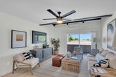 Located in Anaheim, CA, this thoughtfully designed one-bedroom, one-bathroom home offers a cohesive blend of modern updates and warm, inviting character across a single floor. The living room is a standout space, featuring bold exposed black ceiling beams, light wood-style flooring, and sliding glass doors that flood the room with natural light while providing direct outdoor access. A wall-mounted TV niche, a mini-split HVAC unit, and a ceiling fan add both comfort and function to this well-appointed gathering space. The kitchen has been beautifully updated with gray shaker-style cabinetry, quartz countertops with a marble-look backsplash, stainless steel appliances including a gas range and French door refrigerator, and a striking black candelabra chandelier. A round dining table with wicker chairs sits comfortably within the kitchen area. The spacious bedroom features a ceiling fan, a natural light-filled window with shutters, and a mirrored sliding closet that enhances the sense of space. The bathroom is finished with quartz countertops, an undermount sink, and clean white cabinetry with matte black hardware, offering a crisp, contemporary feel throughout.