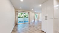Located in Van Nuys, Los Angeles, this thoughtfully updated one-bedroom, one-bathroom unit offers a clean, modern aesthetic throughout. The open-concept living and kitchen area is anchored by light wood-tone flooring and recessed lighting, creating a bright and welcoming atmosphere. Large sliding glass doors in the living room open to a private balcony overlooking mature trees, flooding the interior with natural light and bringing a refreshing outdoor connection indoors. An additional window further enhances the airy feel of the space.

The galley-style kitchen is efficiently designed with sleek white cabinetry, dark countertops, a stainless steel sink with a flexible faucet, and a full suite of stainless steel appliances, including a gas range, dishwasher, and refrigerator. Light-toned tile flooring completes the kitchen's contemporary look.

The bedroom features the same warm wood-tone flooring, recessed lighting, built-in upper cabinetry for additional storage, and a mirrored sliding closet that enhances the sense of space. A window with curtains allows for natural light and privacy.

The bathroom is finished with marble-style tile accents, a full soaking tub with a shower, white subway tile surround, and brushed nickel fixtures, offering a clean and polished retreat. A hallway connects the rooms, completing this well-organized and move-in-ready layout.