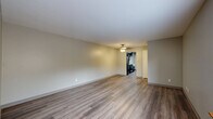 Located at 3215 West Colony Drive in Greenfield, Wisconsin, this single-floor residence offers a thoughtfully designed layout with 2 bedrooms, 2 bathrooms, and an impressive five closets for abundant storage throughout. The interior is unified by warm wood-look luxury vinyl plank flooring that extends seamlessly from room to room, complemented by neutral-toned walls that create a clean, modern aesthetic.

The spacious living room serves as the heart of the home, featuring a ceiling fan with light fixture and open sightlines into the kitchen beyond. The galley-style kitchen is a standout, equipped with dark espresso cabinetry, light granite-style countertops, and a sink — a sleek and functional workspace with a door providing exterior access.

Both bedrooms are generously proportioned, each featuring large bi-fold closet doors that maximize storage. The primary bedroom offers two closets, while the second bedroom includes its own dedicated closet space. A ceiling fan with lighting fixture enhances comfort in the primary bedroom.

The bathrooms are finished with wood-look flooring and include a full tub-shower combination with tile surround, a vanity, and clean, contemporary fixtures. The overall ambiance throughout the residence is bright, neutral, and move-in ready, offering a comfortable and modern living environment.