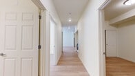 Located at 320 Lincoln St in Fairview, Oregon, this single-floor residence offers a thoughtfully designed two-bedroom, two-bathroom layout with a clean, modern aesthetic throughout. Light wood-look flooring runs continuously across all rooms, creating a cohesive and bright atmosphere.

The kitchen is a standout feature, outfitted with white shaker-style cabinetry, dark countertops, and a full suite of stainless steel appliances including a refrigerator, range, and dishwasher. A long hallway connects the main living areas to the bedrooms, with in-unit laundry conveniently tucked along the corridor.

The primary bedroom provides a comfortable retreat with a closet featuring a sliding door and built-in rod. The second bedroom benefits from natural light through multiple windows with blinds, creating a bright and welcoming space. Both bedrooms feature the same warm wood-look flooring found throughout the home.

The two bathrooms are well-appointed with dark countertops, white cabinetry, and large mirrors. One bathroom includes accessibility features such as grab bars and an open under-sink vanity, while the second offers a full tub-shower combination with a curved rod. The overall design is clean, functional, and move-in ready.