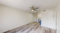 Located at 5150 W Eugie Ave in Glendale, Arizona, this single-story, one-bedroom, two-bathroom unit offers a well-designed layout that makes the most of its compact footprint. Throughout the home, light-toned wood-look flooring provides a clean, contemporary foundation that ties each room together seamlessly.

The main living area is open and airy, bathed in natural light from a large sliding glass door fitted with vertical blinds. A ceiling fan with a built-in light fixture adds both comfort and practicality. Built-in shelving along one wall offers convenient storage and display space, while the textured ceiling adds a classic touch consistent across the unit.

The kitchen is efficiently arranged and accessible from the main living space, featuring appliances and ample cabinetry as seen in the dollhouse view.

The bedroom is a comfortable, well-proportioned space with a dedicated ceiling fan, a natural light-admitting window with vertical blinds, and wood-look flooring that continues from the main living area.

The two bathrooms are clean and modern in finish. One features a stylish floating vanity with charcoal-toned cabinetry, a white countertop, and a large mirror, with a separate water closet. The second bathroom includes a full tub-shower combo with a curved curtain rod and crisp white surround.

A dedicated closet completes the layout, adding practical storage to this tidy, move-in-ready Glendale home.