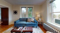 Located at 11 Shepley Street in the heart of Portland, Maine, this single-floor residence blends classic New England character with thoughtful modern updates throughout its well-appointed layout.

The living room is a welcoming retreat, featuring rich hardwood flooring, elegant crown molding, and a large double-hung window that frames views of mature trees and fills the space with natural light. A cast-iron radiator speaks to the home's historic charm, complementing the warm, inviting atmosphere.

The bedroom continues the classic aesthetic, showcasing crown molding, hardwood floors, and a bright window that allows ample daylight to filter in. The room offers a quiet, restful ambiance suited for comfortable living.

The kitchen is a standout, featuring a two-tone cabinet design with crisp white upper cabinets accented by gold hardware and rich dark lower cabinets. Dark countertops, a white subway tile backsplash, and black appliances complete the polished, contemporary look, while light flooring adds a clean, airy contrast.

The bathroom is finished with neutral tile flooring, white shiplap-style wall tiles, a walk-in shower with matte black fixtures, and a clean white vanity — offering a fresh, modern feel.

This residence at 11 Shepley Street delivers a harmonious blend of historic Portland character and updated finishes throughout.