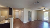 This single-story home features three bedrooms and two full bathrooms within a well-organized floor plan. The main living area is finished with rich, dark wood-look flooring that extends through the entryway, dining area, and into the kitchen. A ceiling fan with a light fixture is installed overhead, and a window along the exterior wall allows natural light to brighten the space. A dedicated dining area sits adjacent to the kitchen, providing a defined space for meals.

The kitchen is equipped with dark cabinetry, a double-basin stainless steel sink, laminate countertops, and a black refrigerator. A doorway from the kitchen leads to a laundry area. Textured ceilings are consistent throughout the main living spaces.

Each of the three bedrooms features plush carpet flooring and a ceiling fan. Two of the bedrooms include windows with blinds that admit natural light, while all three offer ample wall space for furniture placement.

Both bathrooms are finished with tile flooring and dark vanity cabinetry with light countertops. One bathroom includes a tub/shower combination with a curved curtain rod, while the other features a vanity with sink and toilet. The overall aesthetic is neutral and functional throughout.
