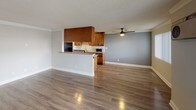 Located at 11650 National Blvd in Los Angeles, CA, this single-floor unit offers a well-designed layout that balances comfort and functionality. The open living area features rich hardwood-style flooring, neutral gray walls, and a ceiling fan that enhances air circulation. Large windows dressed with vertical blinds allow natural light to fill the space, creating a bright and welcoming atmosphere.

The kitchen is thoughtfully designed with warm wood cabinetry, granite countertops, a herringbone tile backsplash, and stainless steel appliances including a gas range and refrigerator. A raised breakfast bar provides a seamless transition between the kitchen and the main living area, making the layout ideal for both everyday living and entertaining.

The bedroom is generously sized, finished with plush carpeting, gray accent walls, and plantation shutters that offer both privacy and natural light. A full wall of mirrored sliding closet doors adds depth and ample storage to the space. A ceiling fan completes the room's comfortable ambiance.

The bathroom features a granite-topped vanity with warm wood cabinetry, a large mirror, and clean, light-toned flooring. Overall, the unit presents a cohesive, updated aesthetic throughout, combining practical finishes with a comfortable, modern feel well-suited to Los Angeles living.
