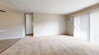 Located at 2401 W Roberta Ave in Fullerton, CA, this one-bedroom, two-bathroom residence offers a practical and well-organized single-floor layout. The open-concept kitchen flows directly into the living and dining areas, creating a cohesive and functional common space. The kitchen features white cabinetry, a granite-style countertop, a stainless steel sink, a gas range, and a dishwasher, all set atop light wood-style flooring. The living area is finished with plush wall-to-wall carpeting and includes a wall-mounted air conditioning unit for climate control, with access to a private balcony that brings in natural light through vertical blinds. The generously sized bedroom offers views of outdoor greenery through a large window fitted with vertical blinds, and includes direct access to a dedicated walk-in closet equipped with built-in shelving and hanging rods. Both bathrooms are finished with clean, modern fixtures, including a full tub-shower combination with a tile surround and light wood-style flooring. A hallway connects the main living spaces efficiently. Throughout, neutral wall tones and clean white trim contribute to a bright, cohesive aesthetic.
