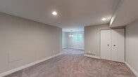 Located at 5902 Cross Country Blvd in Towson, Maryland, this single-floor unit offers a thoughtfully laid-out interior designed for comfortable everyday living. The spacious main living area is finished with plush wall-to-wall carpeting and neutral gray walls, creating a clean and versatile backdrop. Recessed lighting illuminates the open space, while a pendant chandelier adds a subtle decorative touch near a window that draws in natural light. A sliding glass door in one area of the living space provides direct access to an outdoor area, enhancing the connection between interior and exterior.

The kitchen features white shaker-style cabinetry with brushed nickel hardware, dark laminate countertops, a stainless steel sink, and a gas range with an overhead ventilation hood. Light wood-look flooring runs throughout the kitchen, offering a clean contrast to the carpeted living areas. A washer is also visible within the kitchen vicinity, adding practical in-unit laundry convenience.

The bedrooms are carpeted and bathed in natural light through corner windows fitted with blinds. The bathrooms include a full tub-shower combination with white surround, as well as a vanity with white countertops and wood-tone flooring, providing a crisp, functional finish throughout.
