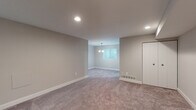 Located at 5902 Cross Country Blvd in Towson, Maryland, this single-floor unit offers a thoughtfully laid-out interior designed for comfortable everyday living. The spacious main living area is finished with plush wall-to-wall carpeting and neutral gray walls, creating a clean and versatile backdrop. Recessed lighting illuminates the open space, while a pendant chandelier adds a subtle decorative touch near a window that draws in natural light. A sliding glass door in one area of the living space provides direct access to an outdoor area, enhancing the connection between interior and exterior.

The kitchen features white shaker-style cabinetry with brushed nickel hardware, dark laminate countertops, a stainless steel sink, and a gas range with an overhead ventilation hood. Light wood-look flooring runs throughout the kitchen, offering a clean contrast to the carpeted living areas. A washer is also visible within the kitchen vicinity, adding practical in-unit laundry convenience.

The bedrooms are carpeted and bathed in natural light through corner windows fitted with blinds. The bathrooms include a full tub-shower combination with white surround, as well as a vanity with white countertops and wood-tone flooring, providing a crisp, functional finish throughout.