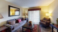 Located at 25 Pelham Rd in Greenville, South Carolina, this single-story residence offers a well-organized layout designed for comfortable everyday living. The living room serves as a welcoming central space, featuring warm tones, wood-style flooring, a large sliding glass door that invites natural light, and a sizable wall mirror that enhances the sense of openness. The room flows naturally into the dining area, which accommodates a glass-top dining table beneath a pendant light fixture, with a lush indoor plant adding a touch of greenery to the corner.

The kitchen is efficiently designed with white cabinetry, dark granite-style countertops, a mosaic tile backsplash, and black appliances including an electric range with an overhead ventilation hood. The layout allows for a direct sightline into the dining area, making the space feel connected and social.

The residence includes multiple bedrooms, each carpeted and filled with natural light through blinds-fitted windows. The rooms offer ample space for full bedroom furnishings. The bathrooms are finished with granite-style vanity countertops, framed mirrors, and a tub-shower combination, reflecting a consistent and cohesive design throughout. Overall, the home presents a warm, functional, and inviting atmosphere.