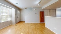 Located in Kansas City, MO, this two-story residence offers two bedrooms and three bathrooms thoughtfully distributed across two floors. The main level features an open-concept living and dining area bathed in natural light from large windows, with warm hardwood-style flooring throughout. A cozy corner fireplace serves as a focal point in the living room, while track lighting adds a modern touch overhead. The kitchen is accessible via a pass-through counter and is outfitted with warm oak cabinetry, light countertops, and stainless steel appliances including a refrigerator, range, and over-the-range microwave. A carpeted staircase leads to the upper level, where both bedrooms are found. Each bedroom features plush carpeting, a ceiling fan, and natural light from windows. The primary bedroom includes an attached closet and a private bathroom with an oak vanity and generous counter space. A second full bathroom on the upper level echoes the same clean, neutral aesthetic with tile flooring and warm wood cabinetry. Additional bathrooms and closet space round out a practical and comfortable layout well-suited for everyday living.