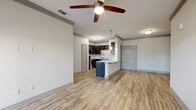 Located in Melbourne, FL, this single-floor, 2-bedroom, 2-bathroom residence offers a thoughtfully designed open-concept layout. The combined kitchen and living area serves as the heart of the home, featuring light wood-look flooring, crown molding, and a ceiling fan. The kitchen is outfitted with dark espresso cabinetry, stainless steel appliances including a full-size refrigerator, a granite-topped island with an undermount sink and pendant lighting, and ample counter and storage space. The living area receives abundant natural light through multiple windows and includes access to an exterior door, enhancing connectivity to the outdoors. Both bedrooms are finished with plush carpeting, ceiling fans, and windows that bring in natural light. The spacious primary bedroom connects to a well-appointed bathroom featuring a granite-topped dark vanity, a framed mirror, and a glass-enclosed shower, as well as a generously sized walk-in closet with wire shelving. A hallway links the rooms cohesively, and two dedicated closets provide practical storage throughout. The overall aesthetic is clean and contemporary, with neutral tones and consistent finishes creating a cohesive, comfortable living environment.