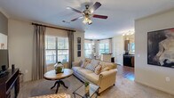 Located at 601 Giddings Ct in Augusta, GA, this thoughtfully designed 2-bedroom, 2-bathroom residence offers a comfortable and functional single-floor layout. The open-concept living room greets you with plush carpeting, crown molding, a ceiling fan, and multiple windows dressed with elegant drapes and blinds that invite abundant natural light. A built-in electric fireplace anchors the room, adding warmth and character. The adjacent dining area is framed by a bay of windows, creating a bright, airy nook ideal for entertaining. The kitchen features rich dark cabinetry, dark countertops, a double sink, and black appliances including a range, microwave, and refrigerator, all complemented by hardwood-style flooring. The generously sized primary bedroom includes a ceiling fan, walk-in closet, and plush carpeting, while the second bedroom mirrors the same comfort with natural light and ample storage. Both bathrooms are finished with dark countertops and wood-toned cabinetry. A dedicated in-unit laundry room with side-by-side washer and dryer adds everyday convenience. Two hallways and two closets round out the well-organized floor plan, making this residence as practical as it is inviting.