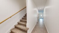 Located at 800 East Spring Street in Cookeville, Tennessee, this two-story home offers a well-organized layout across two floors. The main level provides a welcoming entry through a bright hallway with light wood-style flooring, leading to an open living room equipped with a ceiling fan, an electric fireplace with a classic mantel surround, and built-in shelving. The kitchen is outfitted with white shaker-style cabinetry, granite-look countertops, and black appliances including a range, dishwasher, microwave, and refrigerator, all set over durable wood-style flooring. A dedicated laundry room with washer and dryer hookups and wire shelving, along with a utility room and hallway, round out the lower level. The upper floor hosts both bedrooms, each featuring plush carpeting, ceiling fans with light fixtures, and bright windows that invite natural light. The generously sized primary bedroom includes a spacious walk-in closet with wire shelving on multiple walls. Additional closets throughout the home provide exceptional storage capacity. Three full bathrooms serve the residence, including one featuring a sleek sliding glass walk-in shower and granite-look vanity surfaces. Carpeted staircases with wood handrails connect the two levels, completing this clean, functional home.