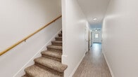 Located at 800 East Spring Street in Cookeville, Tennessee, this two-story home offers a well-organized layout across two floors. The main level provides a welcoming entry through a bright hallway with light wood-style flooring, leading to an open living room equipped with a ceiling fan, an electric fireplace with a classic mantel surround, and built-in shelving. The kitchen is outfitted with white shaker-style cabinetry, granite-look countertops, and black appliances including a range, dishwasher, microwave, and refrigerator, all set over durable wood-style flooring. A dedicated laundry room with washer and dryer hookups and wire shelving, along with a utility room and hallway, round out the lower level. The upper floor hosts both bedrooms, each featuring plush carpeting, ceiling fans with light fixtures, and bright windows that invite natural light. The generously sized primary bedroom includes a spacious walk-in closet with wire shelving on multiple walls. Additional closets throughout the home provide exceptional storage capacity. Three full bathrooms serve the residence, including one featuring a sleek sliding glass walk-in shower and granite-look vanity surfaces. Carpeted staircases with wood handrails connect the two levels, completing this clean, functional home.