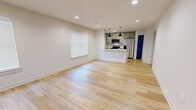 Located at 4229 Second Alley S in Birmingham, AL, this 2-bedroom, 2-bathroom single-story unit offers a well-designed, modern interior with thoughtful finishes throughout. The open-concept living and kitchen area serves as the heart of the home, where light-toned hardwood flooring extends across the space, reflecting natural light from multiple windows fitted with white blinds. Recessed lighting complements the room's clean, neutral palette of crisp whites and warm beige tones.

The kitchen is a standout feature, anchored by a peninsula with a granite countertop, undermount sink, and seating potential. Gray shaker-style cabinetry reaches toward the ceiling for ample storage, while stainless steel appliances, including a side-by-side refrigerator, range, and microwave, complete the space. Bold navy-blue accent doors add a distinctive design element seen throughout the unit.

Both bedrooms feature plush carpeting and ceiling fans, with the primary bedroom offering comfortable proportions and its own closet. The bathrooms are finished with granite vanity tops, gray cabinetry, and hardwood-style flooring. Two hallways connect the private areas efficiently, and dedicated closets provide practical storage solutions throughout this well-appointed home.