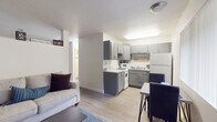 Located on E Prince Road in Tucson, Arizona, this single-floor unit offers a thoughtfully arranged layout that maximizes comfort and functionality. The open-concept living and dining area is anchored by light wood-style flooring that runs throughout, creating a cohesive and airy feel. The living room provides generous space for seating arrangements, with clean white walls, neutral tones, and a decorative ledge that adds a personal touch to the environment.

Adjacent to the living area, a secondary seating space features two barrel-style chairs, a patterned area rug, and nature-inspired wall art, offering a quiet retreat or flex space. The kitchen is efficiently designed with updated gray cabinetry, light quartz-style countertops, white appliances including a refrigerator, electric range, and microwave, as well as ample upper and lower cabinet storage. A dining area sits just off the kitchen, making everyday meals convenient.

The bathroom is finished with a gray vanity, a well-lit mirror, and light flooring, complemented by a nearby closet offering practical storage. The overall color palette — whites, grays, and natural wood tones — gives the space a clean, modern aesthetic. Every area is thoughtfully detailed to provide a comfortable and move-in-ready living experience in central Tucson.