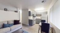 Located on E Prince Road in Tucson, Arizona, this single-floor unit offers a thoughtfully arranged layout that maximizes comfort and functionality. The open-concept living and dining area is anchored by light wood-style flooring that runs throughout, creating a cohesive and airy feel. The living room provides generous space for seating arrangements, with clean white walls, neutral tones, and a decorative ledge that adds a personal touch to the environment.

Adjacent to the living area, a secondary seating space features two barrel-style chairs, a patterned area rug, and nature-inspired wall art, offering a quiet retreat or flex space. The kitchen is efficiently designed with updated gray cabinetry, light quartz-style countertops, white appliances including a refrigerator, electric range, and microwave, as well as ample upper and lower cabinet storage. A dining area sits just off the kitchen, making everyday meals convenient.

The bathroom is finished with a gray vanity, a well-lit mirror, and light flooring, complemented by a nearby closet offering practical storage. The overall color palette — whites, grays, and natural wood tones — gives the space a clean, modern aesthetic. Every area is thoughtfully detailed to provide a comfortable and move-in-ready living experience in central Tucson.
