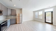 Located at 800 E Long Street in Columbus, Ohio, this well-appointed one-bedroom, one-bathroom unit offers a thoughtfully designed single-floor layout. The open-concept kitchen and living area serves as the heart of the home, featuring light wood-style flooring that extends throughout. The kitchen is outfitted with gray shaker-style cabinetry, granite-look countertops, a classic subway tile backsplash, and a full suite of stainless steel appliances including a refrigerator, electric range, microwave, and dishwasher. A pendant light adds a finishing touch above the workspace. The living area benefits from natural light through multiple windows, creating a bright and welcoming atmosphere. The bedroom is carpeted for comfort, with a window that brings in additional natural light, and is complemented by a spacious walk-in closet with wire shelving for ample storage. The bathroom features a clean, modern walk-in shower with glass sliding doors and brushed nickel fixtures. A dedicated in-unit laundry area adds everyday convenience. Neutral wall tones and clean finishes throughout give the space a fresh, move-in-ready appeal.