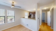This single-floor, 2-bedroom, 1-bathroom residence offers a thoughtfully designed layout that maximizes functionality and comfort. The living room serves as the heart of the home, featuring light hardwood flooring, a textured ceiling, and a tile-surround fireplace as a focal point. A large sliding glass door floods the space with natural light and provides views of the surrounding greenery outdoors. A ceiling fan adds to the room's practicality.

The kitchen is open and accessible via a half-wall pass-through with granite countertops, creating a seamless connection to the living area. Dark espresso cabinetry, a mosaic tile backsplash, stainless steel appliances including a refrigerator and range, and multiple windows make the kitchen both stylish and functional.

Both bedrooms are carpeted and offer a calm, neutral palette. The primary bedroom includes a sliding glass door that opens to an outdoor area with mature landscaping. The second bedroom is comfortably sized with neutral walls and built-in heating.

The bathroom features a full tub-shower combination with tile surround, dark cabinetry with a countertop vanity, and light flooring consistent with the rest of the home. A connecting hallway ties all rooms together in a practical, easy-to-navigate floor plan.