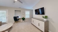 This well-appointed single-story residence in Greenwood, South Carolina offers a thoughtfully designed layout across two bedrooms and two bathrooms. Neutral warm-gray tones throughout create a cohesive, calming ambiance that ties each room together seamlessly.

The galley-style kitchen features white shaker cabinetry, granite countertops, stainless steel appliances, and tile flooring, with direct sightlines into the adjacent dining area. The dining space is distinguished by wainscoting along the lower walls, a brushed nickel chandelier, and decorative wall accents, lending a polished, refined character to everyday meals.

The living room offers plush carpeting and natural light from a sliding glass door, creating a comfortable gathering space. Both bedrooms are carpeted and include ceiling fans with light fixtures. The primary bedroom provides a dedicated walk-in closet with wire shelving and natural light from a window. The primary bathroom features large-format tile flooring, a granite vanity, and a glass-enclosed shower.

A dedicated laundry room houses a full-size washer and dryer. A connecting hallway ties all areas together efficiently, maximizing the functionality of this compact yet complete home.