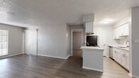 Located at 2701 W Waters Ave in Tampa, FL, this 2-bedroom, 2-bathroom unit offers a practical and well-organized single-floor layout. The living room features wood-style laminate flooring, neutral gray walls, a textured ceiling, and a large window with vertical blinds that invite natural light. A sliding glass door with vertical blinds opens to an outdoor area, adding to the bright, airy feel of the space. The living area flows seamlessly into the combined dining and kitchen space. The dining area includes a pendant light fixture and a clean, open layout, while the galley-style kitchen is outfitted with white shaker cabinetry, light quartz countertops, a stainless steel sink, and stainless appliances including a range and refrigerator. Both bedrooms are carpeted for comfort, with neutral tones and ample natural light from individual windows. The primary bedroom features a walk-in closet with built-in shelving, while the second bedroom includes a double-door closet. Each bathroom is clean and functional, offering a tub-shower combination with white tile surround, a white vanity with quartz countertops, and wood-style flooring. A hallway and dedicated closet provide additional storage throughout this efficiently designed residence.