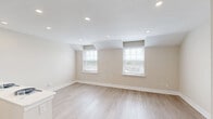 Located at 349 Chilton Ct in Plymouth Meeting, PA, this thoughtfully designed one-bedroom, one-bathroom unit offers a clean, modern aesthetic throughout. The open-concept kitchen and living area serves as the heart of the home, featuring light wood-look flooring, recessed lighting, and a bright, neutral color palette. The kitchen is well-appointed with two-tone cabinetry — crisp white upper cabinets paired with rich dark wood lower cabinets — complemented by quartz countertops, a classic white subway tile backsplash, a stainless steel undermount sink, and a full suite of stainless steel appliances including a refrigerator, range, microwave, and dishwasher. A peninsula provides additional prep and dining space. The living area benefits from dual windows that invite natural light and offer views of the surrounding neighborhood. The spacious bedroom is finished with plush wall-to-wall carpeting, additional windows, and access to multiple closets, including a dedicated wardrobe closet with built-in racking. The bathroom features full-height tile surround in a soft neutral tone, a tub-shower combination with a handheld showerhead, built-in niche shelving, and a modern LED-lit vanity mirror. A utility room and hallway with additional closet storage complete the layout.