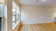 Located at 900 3rd St SE in Cedar Rapids, Iowa, this thoughtfully designed one-bedroom, one-bathroom unit offers a clean, modern aesthetic throughout its efficiently utilized single-floor layout. The open-concept kitchen and living area serves as the heart of the space, featuring light hardwood-style flooring, white shaker cabinetry, white quartz countertops, and a peninsula with an integrated sink illuminated by stylish pendant lights. Stainless steel appliances, including a refrigerator, range, and over-the-range microwave, complete the kitchen. Large windows in the living area allow abundant natural light and offer views of the surrounding Cedar Rapids cityscape. The bedroom is comfortably sized with soft carpeting, a ceiling fan, and a window providing additional natural light and urban views. The bathroom is finished with white cabinetry, a vanity mirror, and a shower-tub combination, all set over warm hardwood-style flooring. A dedicated laundry area houses a stacked Samsung washer and dryer alongside open wire shelving for added storage. Neutral warm-toned walls and consistent finishes throughout the space contribute to a cohesive, move-in-ready ambiance.