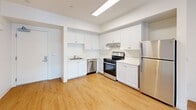 Located at 1400 Long Beach Boulevard in Long Beach, CA, this single-floor, one-bedroom, one-bathroom unit offers a clean, modern aesthetic designed to maximize its compact footprint. Light wood-style flooring runs throughout the space, creating a warm and cohesive look.

The kitchen is a standout feature, outfitted with crisp white shaker cabinets that extend to the ceiling for ample storage, a full suite of stainless steel appliances including a gas range, dishwasher, and refrigerator, and light-toned countertops. A skylight overhead brightens the kitchen, reinforcing the space's airy feel.

The bedroom is a cozy yet functional retreat, featuring a window with vertical blinds that admits natural light and offers views of surrounding greenery. The neutral white walls and wood-style flooring keep the room bright and versatile.

The bathroom maintains the unit's clean design language with a white vanity and basin, a large mirror with overhead lighting, and a shower-tub combination. Wood-style flooring continues here, tying together the overall aesthetic.

Throughout the unit, the all-white walls and consistent flooring create a bright, streamlined atmosphere. The open layout between the kitchen and living area makes efficient use of the available space, offering a functional and modern living environment in the heart of Long Beach.
