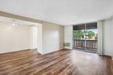 Located at 15529 Williams St in Tustin, California, this 2-bedroom, 1-bathroom residence offers a well-organized layout across its living floor. The open living area features warm wood-look flooring, a textured ceiling, and a ceiling fan with light fixture, creating a bright and functional space. An adjoining area flows naturally toward the hallway and entry, enhanced by a louvered closet door adding a classic touch.

The galley-style kitchen is efficiently designed with white cabinetry, granite-look countertops, a stainless steel sink, and a white electric range. A window at the end of the kitchen fills the space with natural light and offers a pleasant outdoor view.

Both bedrooms are carpeted and include ceiling fans and dedicated closets. The primary bedroom features floor-to-ceiling mirrored sliding closet doors, maximizing both storage and the sense of space. The second bedroom includes a reach-in closet with built-in shelving.

The bathroom is generously proportioned, boasting a dual-sink vanity with granite-look countertops, white cabinetry, and wood-look flooring that continues throughout. A balcony provides outdoor access with a scenic view of the landscaped community grounds and a sparkling pool below.