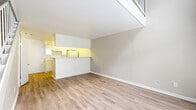 Located at 6500 W 43rd St in Houston, TX, this two-story residence offers a well-organized layout across two floors. The ground floor opens into a bright living room featuring light wood-look flooring, neutral-toned walls, and a large window that allows natural light to fill the space. A staircase leads to the upper level, with a railing visible from the living area below, giving the home an open, airy feel. The galley-style kitchen is positioned adjacent to the living room and is accessible via a pass-through counter. It is equipped with white cabinetry, a coil-burner range, a full-size refrigerator, a dishwasher, and a double sink with granite-look countertops — offering a clean and functional cooking space. Upstairs, the generously sized primary bedroom features plush carpeting, a ceiling fan, a window with natural light, and an open-railing overlook. A dedicated closet provides ample storage. The full bathroom includes a single-sink vanity with granite-look countertops, mirrored medicine cabinet, and a tub-shower combo with white tile surround. Throughout the home, the consistent use of light tones and wood-look flooring on the main level creates a cohesive and welcoming atmosphere.