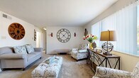 This thoughtfully designed single-floor home offers a practical and comfortable layout across two bedrooms, one bathroom, and a collection of well-defined living spaces. The carpeted living room is bright and welcoming, featuring large windows that allow natural light to fill the room, neutral white walls, and generous space for seating arrangements. The open feel of the living area flows naturally into the dining room, creating an ideal setting for everyday living and entertaining. The kitchen is equipped with warm wood cabinetry, a tile backsplash, solid countertops, and a stainless steel sink, offering a functional workspace with ample storage. The primary bedroom is a comfortable retreat, featuring carpet flooring, a window with natural light, and dual closets with built-in shelving and hanging rods for well-organized storage. The second bedroom also features carpet and a window, providing a versatile space. The full bathroom includes warm wood vanity cabinetry, a white countertop, and a shower/tub combination. With three closets distributed throughout the home, storage is plentiful. The hallway connects all areas efficiently, contributing to the home's practical and cohesive single-level flow.