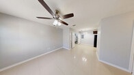 This single-floor, 2-bedroom, 1-bathroom unit offers a practical and functional layout designed to maximize every square foot. Light-toned tile flooring runs throughout the space, providing a clean, cohesive look that ties each room together.

The kitchen is a standout feature, showcasing rich dark wood cabinetry that extends to the ceiling for ample storage, granite countertops with a double-basin stainless steel sink, and black appliances including a refrigerator and range. The galley-style layout keeps everything within easy reach.

Both bedrooms are comfortably sized and feature ceiling fans with integrated lighting. The primary bedroom offers a generous footprint, neutral gray walls, and a doorway leading directly to the kitchen area. The second bedroom includes a window that brings in natural light and a closet for storage. Both rooms share the same clean tile flooring.

The bathroom is fitted with a tub-shower combo surrounded by floor-to-ceiling tile, chrome fixtures, a built-in shower niche, and dark wood overhead cabinetry for added storage. A dedicated utility room rounds out the unit, providing additional functional space. Overall, the unit presents a clean, move-in ready environment with consistent finishes throughout.
