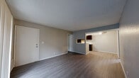 Located at 2102 E 51st St S in Tulsa, Oklahoma, this single-story 2-bedroom, 2-bathroom unit offers a practical and well-organized floor plan. The open-concept living, dining, and kitchen area forms the heart of the home, featuring wood-style laminate flooring and a textured ceiling throughout. The living room receives natural light through a sliding glass door fitted with vertical blinds, which opens directly onto a private patio. The kitchen is equipped with dark espresso cabinetry, a stainless steel sink, a ceiling fan, and black appliances including a range and refrigerator, complemented by light-colored countertops and matching laminate flooring. Both bedrooms are carpeted and finished with neutral wall tones, offering a quiet and comfortable retreat. The primary bedroom is a generous size and includes access to a closet. The unit features two full bathrooms, each with a tiled tub-and-shower combination. One bathroom includes a vanity with dark cabinetry and a light countertop. Four closets distributed throughout the unit provide substantial storage capacity. A connecting hallway ties the living spaces and bedrooms together efficiently, making this a functional and well-appointed home.