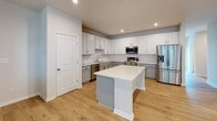 Located at 1601 Overbrook Rd in Richmond, Virginia, this two-floor residence offers a thoughtfully designed interior with a clean, contemporary aesthetic. The main level features an expansive open-concept living area with light hardwood flooring, recessed lighting, and a ceiling fan, creating a bright and airy atmosphere. Large windows along the living space invite natural light and provide a welcoming sense of openness. A staircase with a wood handrail connects the two floors seamlessly.

The kitchen is a standout feature, outfitted with white shaker-style upper cabinetry, gray lower cabinets, a white quartz countertop, and a classic subway tile backsplash. A center island provides additional prep and seating space, while stainless steel appliances — including a french door refrigerator, range, microwave, and dishwasher — complete the modern look. Hardwood-style flooring continues throughout.

The upper level includes generously sized bedrooms, each with ceiling fans and light flooring. Walk-in closets with wire shelving systems offer practical storage solutions. Bathrooms are finished with hexagonal tile flooring, gray vanity cabinetry, white quartz countertops, brushed nickel fixtures, and a full tub-shower combination, delivering a polished and functional design throughout.