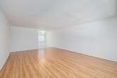 Located in the Playa del Rey neighborhood of Los Angeles, this single-story 2-bedroom, 2-bathroom home offers a clean, bright, and functional layout. Warm honey-toned hardwood-style flooring runs throughout the main living areas and bedrooms, complementing the crisp white walls and creating a light, airy atmosphere.

The spacious living room is bathed in natural light from a large window fitted with vertical blinds, providing an open and welcoming gathering space. The kitchen features tile flooring, white cabinetry, and a generously sized window with vertical blinds that lets in abundant sunlight and outdoor views of surrounding greenery.

The primary bedroom is comfortably sized, with hardwood-style flooring, neutral white walls, and a large sliding-door closet offering ample built-in storage with dual hanging rods. The second bedroom also features matching flooring and a wide window with horizontal blinds that frames pleasant outdoor views.

Both bathrooms are finished with tiled tub-shower combinations — one with crisp white square tile and a white vanity with mirror, and the other with warm beige tile and a window for natural ventilation. A connecting hallway links the rooms seamlessly throughout the single-floor layout, completing this well-organized and move-in-ready Los Angeles home.