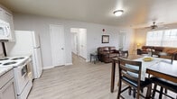 Located at Campus Pointe in Charleston, Illinois, this single-level unit offers three bedrooms and three full bathrooms within a thoughtfully arranged floor plan. Light wood-style flooring runs consistently throughout the space, contributing to a clean, cohesive aesthetic.

The combined living and dining area serves as the central hub of the unit. The living room features a ceiling fan with light fixture and windows that allow natural light to fill the space. A dining area sits adjacent, providing a functional transition toward the kitchen.

The kitchen is well-equipped with gray shaker-style cabinetry, granite-look countertops, a stainless steel sink, and white appliances including a range, over-the-range microwave, dishwasher, and refrigerator. A skylight above the kitchen enhances brightness.

Each of the three bedrooms features neutral gray walls, light flooring, and windows offering outdoor views. The primary bedroom provides a comfortable footprint for furnishings. All three bathrooms include tub/shower combinations with chrome fixtures, wood-toned vanities, and light flooring, maintaining a consistent, clean design throughout the unit.