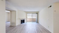 Located at 22501 Del Valle St in the Woodland Hills neighborhood of Los Angeles, this 2-bedroom, 3-bathroom residence offers a thoughtfully laid-out single-floor plan. The main living area is bright and airy, showcasing light wood laminate flooring and a tile-surround fireplace as a focal point. Sliding glass doors lead to a private balcony, allowing natural light to fill the space and providing an outdoor retreat. A second living area features a ceiling fan and an additional window with garden views, flowing seamlessly into the kitchen, which is outfitted with rich wood cabinetry and granite countertops over tile flooring. The bedrooms are comfortably sized, with the primary bedroom offering dedicated closet space, while a secondary bedroom includes mirrored sliding closet doors that enhance the sense of space. Three full bathrooms serve the residence, each with tile flooring; at least one includes a full tub-shower combination with a window for natural ventilation. Textured ceilings are consistent throughout, and the neutral color palette creates a clean, cohesive aesthetic. The layout is practical and efficient, making excellent use of the available square footage in this well-situated Los Angeles property.