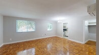 Located at 6079 Bellview Dr in Falls Church, VA, this two-bedroom, one-bathroom unit offers a well-organized single-floor layout. The living area is a standout feature, showcasing beautifully polished parquet hardwood floors that extend throughout the home. Two windows invite generous natural light and offer pleasant views of surrounding greenery, while an elegant chandelier adds a classic finishing touch overhead. The spacious primary bedroom continues the parquet flooring aesthetic and is equipped with a wall-mounted mini-split system for individual climate control, along with a closet for ample storage. The second bedroom is bright and comfortable, featuring its own window that frames outdoor views and the same warm hardwood flooring. The kitchen is functional and well-appointed with white cabinetry, light speckled countertops, a double stainless steel sink, a gas range, and a window that fills the space with natural light. The full bathroom is clean and classic, featuring a tiled tub-shower combination with white square tile surround. A hallway connects the rooms efficiently, completing this cohesive and practical layout in a convenient Northern Virginia location.